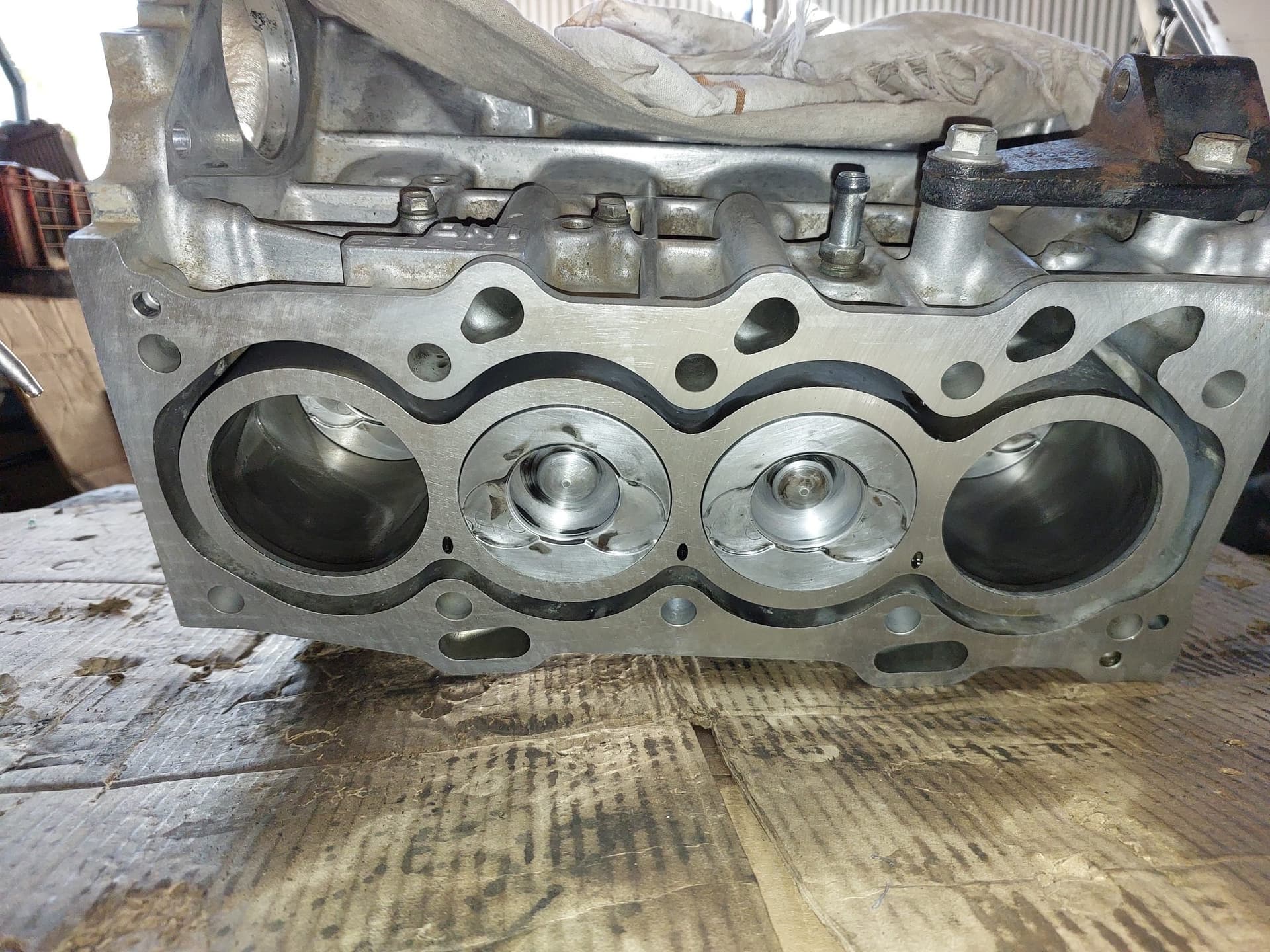 Four-cylinder engine block rebuild with pistons on the workshop floor